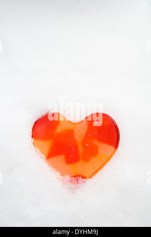 Coeur Orange intégrés dans la neige Banque D'Images