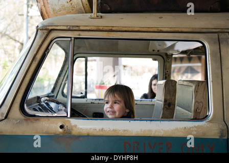 Trois ans vieux garçon assis dans un vieux van au Zoo de Louisville comme mère regarde derrière Banque D'Images