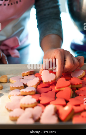 Woman's Hand Holding Cookie Heart-Shaped Banque D'Images