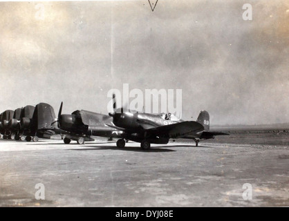 Cette photographie de l’album de Charles Daniels met en valeur deux avions emblématiques de la seconde Guerre mondiale, le Grumman F6F Hellcat et le F4U Corsair. Tous deux étaient essentiels aux opérations de l'US Navy, le Hellcat atteignant un taux d'abattage élevé et le Corsair étant connu pour sa conception distinctive de l'aile de mouette inversée. Banque D'Images