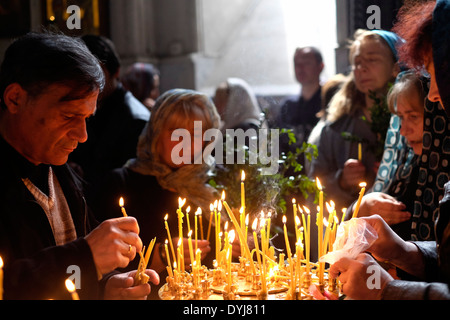 Les Géorgiens allument des bougies pendant que les prient à l'intérieur de l'église Kashveti de Saint-Georges, dans la capitale de la République de Géorgie à Tbilissi Banque D'Images