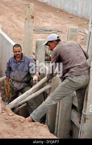 L'installation d'ouvriers de la construction bois traditionnelle pour coffrage de béton sur le nouveau canal pour l'approvisionnement en eau, Marrakech Maroc Banque D'Images