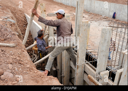 L'installation d'ouvriers de la construction bois traditionnelle pour coffrage de béton sur le nouveau canal pour l'approvisionnement en eau, Marrakech Maroc Banque D'Images