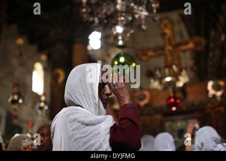 (140420) -- BETHLÉEM, 20 avril 2014 (Xinhua) - Un pèlerin Chrétien prend part à la cérémonie du feu sacré, à l'église de la Nativité, qui est construit sur le site traditionnel de la naissance de Jésus à Bethléem, le 19 avril 2014. Au cours de la cérémonie annuelle, haut clergé entrez l'édicule, la petite chambre marquant l'emplacement de la tombe de Jésus à l'église du Saint-Sépulcre de Jérusalem, traditionnellement considéré comme le lieu de sépulture de Jésus Christ. Ils émergent après pour révéler des bougies allumées par 'feu sacré' dit être miraculeusement allumé comme un message aux fidèles du ciel. Les détails de la flam Banque D'Images