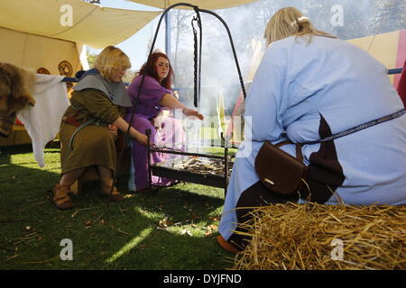 Dublin, Irlande. 19 avril 2014. Reenactors sont assis autour d'une cheminée, barbecue saucisses. Le 1 000 e anniversaire de la bataille de Clontarf entre le haut roi d'Irlande Brian Boru et une coalition de force les royaumes de Dublin, Leinster et Vikings a été célébrée avec un week-end de reconstitutions historiques, qui a réuni environ 40 000 visiteurs. Crédit : Michael Debets/Alamy Live News Banque D'Images