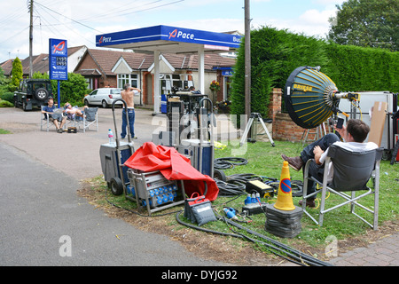 L'équipe du film au cours de détente pause déjeuner sur une chaude journée d'été humide à l'extérieur d'une station-village que l'on croit être à plat seul moyen est Essex England UK Banque D'Images