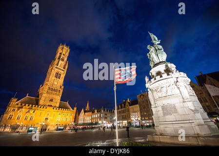 BRUGES, Belgique — le Markt (place du marché) ancre le centre historique de Bruges, un site classé au patrimoine mondial de l'UNESCO. La tour médiévale du beffroi, achevée au XVe siècle, se dresse sur le côté gauche de la place. Une statue éminente commémorant les héros flamands Jan Breydel et Pieter de Coninck, leaders du soulèvement de 1302 contre la domination française, se dresse à droite. Banque D'Images