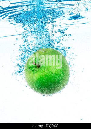 Pomme verte fraîche dans l'eau claire sur fond blanc. Banque D'Images