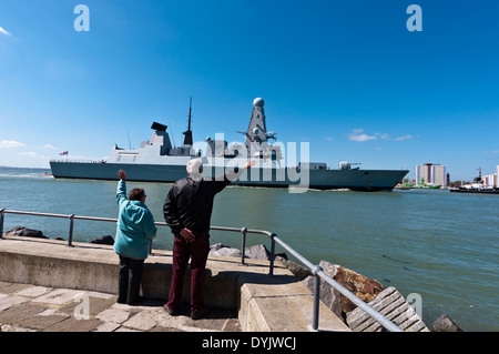 Le HMS Dragon Royal Navy destroyers Type 45 retour à Portsmouth Harbour avec des personnes agitant Banque D'Images