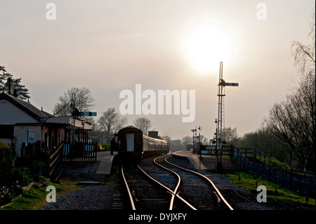 Coucher du soleil sur le Kent et l'East Sussex Railway, avec un train au départ de la gare de Rye Banque D'Images