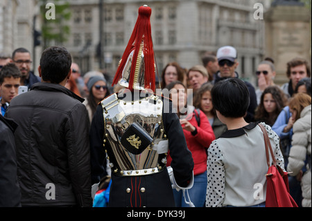 Les touristes de prendre des photos d'un membre de la Royal Horse Guards (Blues) à Horse Guards Whitehall, Londres, Angleterre. Banque D'Images