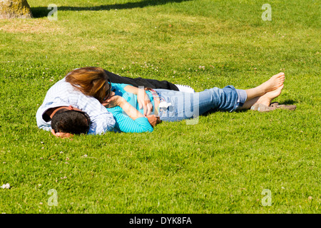 Un jeune couple faire la sieste sur une pelouse. Banque D'Images