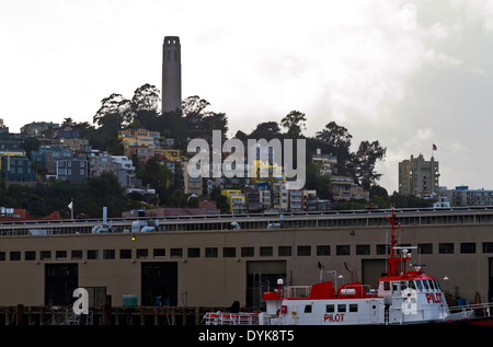 La Coit Tower est vu d'un quai d'Embarcadero avec un bateau-pilote à l'avant-plan à San Francisco. Banque D'Images