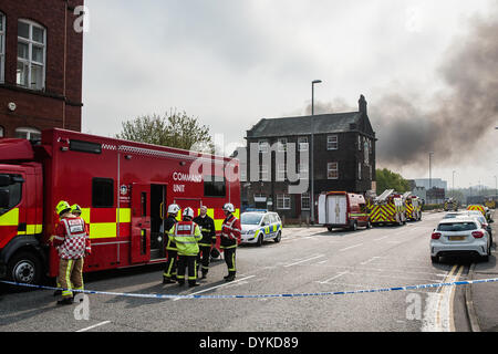 Leeds, West Yorkshire, Royaume-Uni, 21 avril 2014. Une nappe de fumée flotte dans l'air que les pompiers continuent de lutter contre un incendie dans une zone industrielle de Leeds. Image montre l'unité de commande sur Armley Road. L'incendie a éclaté à environ 1,50 heures dans les locaux d'Tradpak une usine de recyclage de l'emballage et de produits chimiques dans l'Armley de la ville. L'usine est à proximité du centre-ville et les résidants des environs ont été dit de garder leurs fenêtres et portes fermées à cause de produits chimiques potentiellement toxiques impliqués. Crédit : Ian Wray/Alamy Live News Banque D'Images