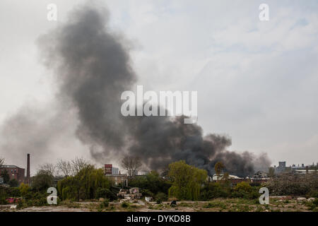 Leeds, West Yorkshire, Royaume-Uni, 21 avril 2014. Une nappe de fumée flotte dans l'air que les pompiers continuent de lutter contre un incendie dans une zone industrielle de Leeds. L'incendie a éclaté à environ 1,50 heures dans les locaux d'Tradpak une usine de recyclage de l'emballage et de produits chimiques dans l'Armley de la ville. L'usine est à proximité du centre-ville et les résidants des environs ont été dit de garder leurs fenêtres et portes fermées à cause de produits chimiques potentiellement toxiques impliqués. Crédit : Ian Wray/Alamy Live News Banque D'Images