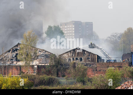 Leeds, West Yorkshire, Royaume-Uni, 21 avril 2014. Un pompier dirige l'eau sur un incendie dans une zone industrielle de Leeds. L'incendie a éclaté à environ 1,50 heures dans les locaux d'Tradpak une usine de recyclage de l'emballage et de produits chimiques dans l'Armley de la ville. L'usine est à proximité du centre-ville et les résidants des environs ont été dit de garder leurs fenêtres et portes fermées à cause de produits chimiques potentiellement toxiques impliqués. Crédit : Ian Wray/Alamy Live News Banque D'Images