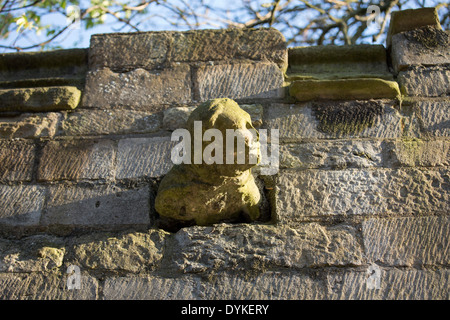 Une gargouille statue comme poussant hors du mur sur Eastgate l'un des murs autour de la cathédrale de Lincoln. Banque D'Images