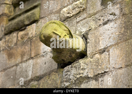 Une gargouille statue comme poussant hors du mur sur Eastgate l'un des murs autour de la cathédrale de Lincoln. Banque D'Images