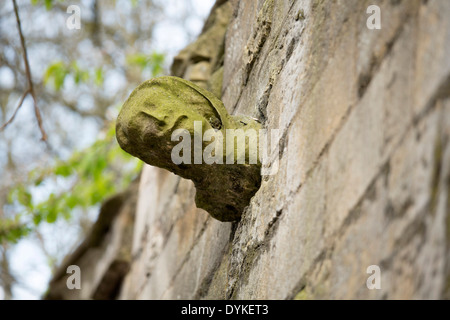 Une gargouille statue comme poussant hors du mur sur Eastgate l'un des murs autour de la cathédrale de Lincoln. Banque D'Images