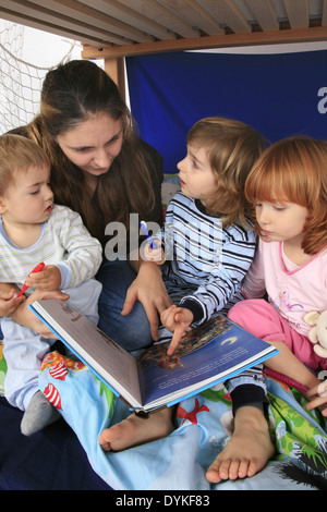 Mère lire un livre à ses enfants dans une Billi-Bolli lit en mezzanine Banque D'Images