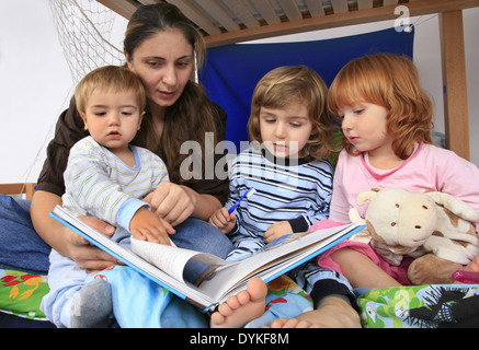 Mère lire un livre à ses enfants dans une Billi-Bolli lit en mezzanine Banque D'Images