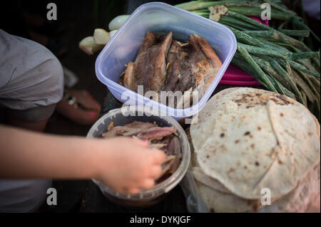 Le Caire, Égypte. Apr 21, 2014. Les Egyptiens mangent le poisson salé et crêpes dans une église alors qu'ils célèbrent la fête traditionnelle ham 'el-Nessim', littéralement traduit comme 'Smell le Breeze", également connu sous le nom de festival du printemps, au Caire, capitale de l'Égypte, le 21 avril 2014. Source : Xinhua/Chaoyue Pan/Alamy Live News Banque D'Images