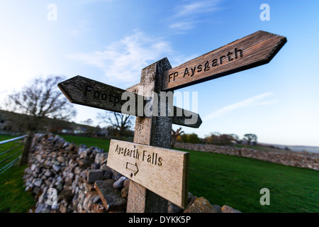 Directions sign post Aysgarth Carperby pointant façon mur de pierre en bois de pierres sèches dans le Yorkshire Dales National Park UK Angleterre GO Banque D'Images