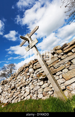 Directions sign post Aysgarth Carperby pointant façon mur de pierre en bois de pierres sèches dans le Yorkshire Dales National Park UK Angleterre GO Banque D'Images