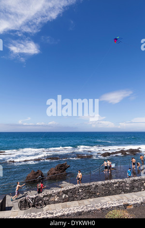 Les baigneurs et les touristes jouant sur les rochers à la Playa de Jaquita à Alcala, Tenerife, Canaries, Espagne Banque D'Images