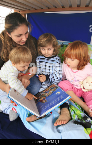 Mère lire un livre à ses enfants dans une Billi-Bolli lit en mezzanine Banque D'Images