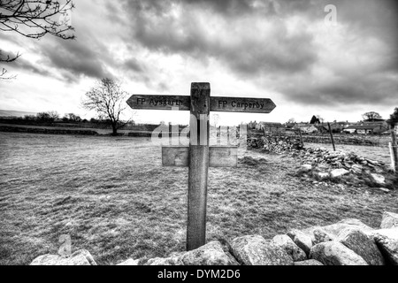 Directions sign post Aysgarth Carperby pointant façon mur de pierre en bois de pierres sèches dans le Yorkshire Dales National Park UK Angleterre GO Banque D'Images