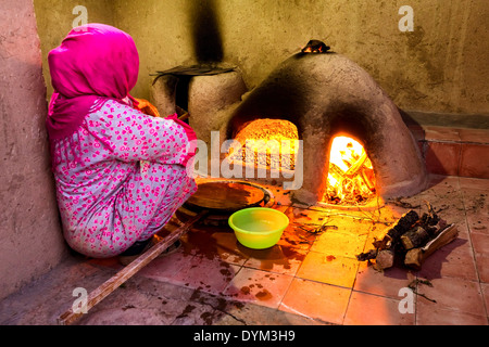 Une femme marocaine traditionnelle de faire le pain dans un four à bois, Scoura, Maroc, Afrique Banque D'Images