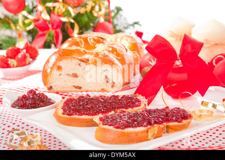 Table de fête traditionnelle avec gâteau de Noël stollen, des boules de noël et l'arbre de Noël en arrière-plan. Rouge et vert traditionnel xm Banque D'Images