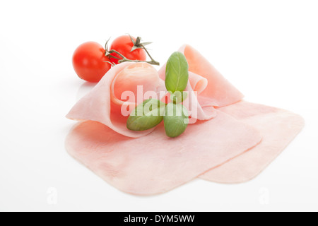 De délicieux Feuilletés au jambon et aux feuilles de basilic frais et tomates cerises isolé sur fond blanc. Manger culinaire. Banque D'Images