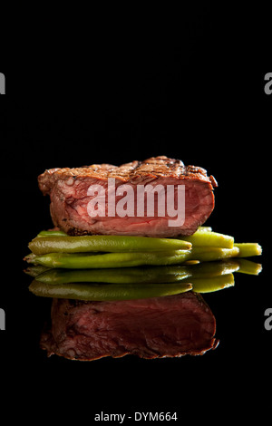 Rosé steak de boeuf et haricots rouges sur fond noir Banque D'Images