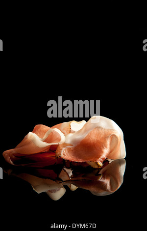 Délicieux prosciutto sur fond noir. Antipasti culinaire Banque D'Images