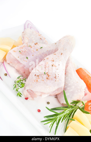 Cuisses de poulet avec légumes frais sur bac blanc encore la cuisson la vie. Banque D'Images