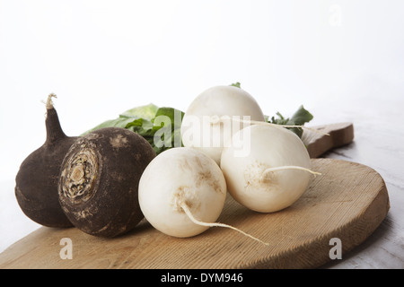 Radis noir et blanc sur la cuisine en bois ronde. Matières premières, frais et sain de manger des légumes. Banque D'Images