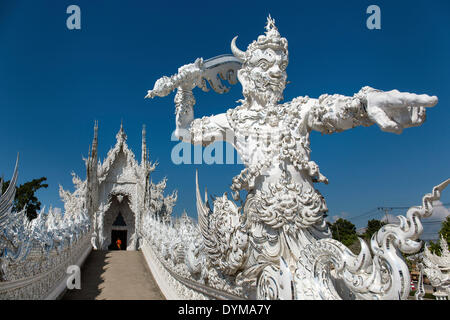 Wat Rong Khun, orné d'un tuteur et de démon sur le pont du Temple blanc par l'architecte et artiste Chalermchai Kositpipat Banque D'Images