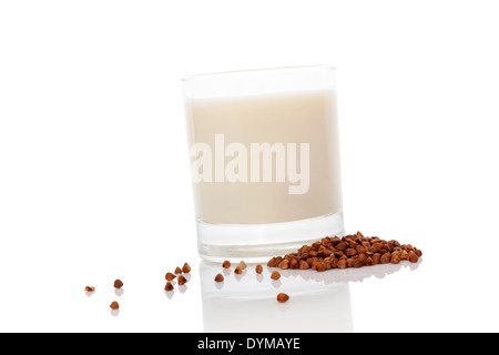 Lait de sarrasin en verre avec des graines de sarrasin à sec isolé sur fond blanc. Végétarien et Végétalien concept de lait. Banque D'Images