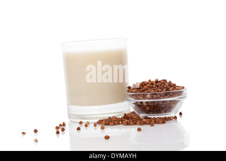 Lait de sarrasin en verre avec des graines de sarrasin à sec dans le bol en verre isolé sur fond blanc. Végétarien et Végétalien concept de lait. Banque D'Images