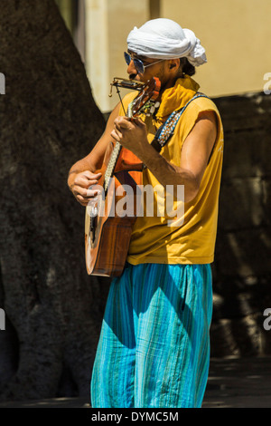 Musicien ambulant qui joue de la guitare et de l'harmonica sur Corso Vittorio Emanuele II historique dans cette ville du patrimoine mondial ; Noto, Sicile, Italie Banque D'Images