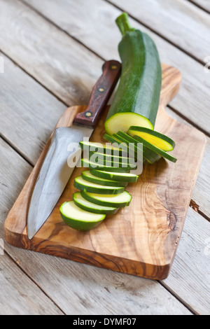 Courgettes en rondelles sur planche en bois avec couteau. Focus sélectif. Banque D'Images