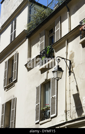 Appartement parisien blanc avec fenêtres, volets, jardinières, et d'un réverbère suspendu Banque D'Images