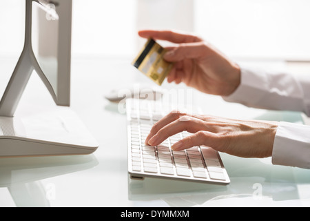 Woman shopping sur internet à l'aide d'ordinateur et une carte de crédit Banque D'Images