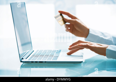 Woman shopping sur Internet avec ordinateur portable et une carte de crédit Banque D'Images