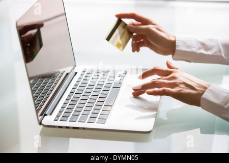 Woman shopping sur Internet avec ordinateur portable et une carte de crédit Banque D'Images