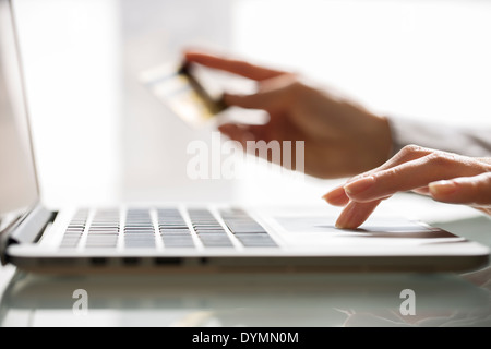 Woman shopping sur Internet avec ordinateur portable et une carte de crédit Banque D'Images