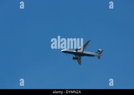 Blue jet avion de passagers avec les roues vers le bas pour l'atterrissage contre clair ciel bleu profond Banque D'Images
