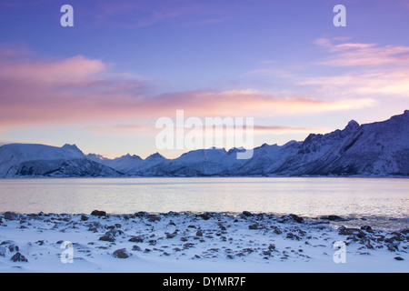 Vue sur le fjord et les montagnes en Gimsøystraumen la neige en hiver au lever du soleil, les îles Lofoten, Nordland, Norvège Banque D'Images